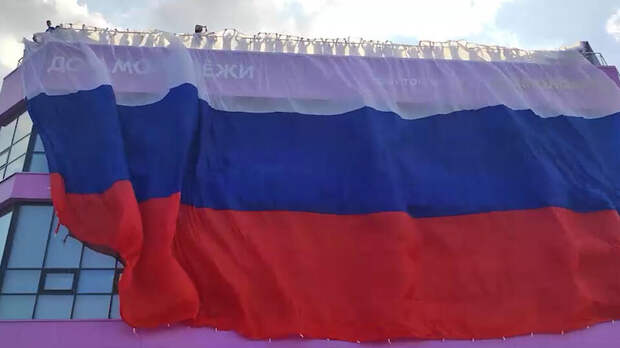 Активисты растянули гигантский флаг РФ на Доме Молодежи в Луганске