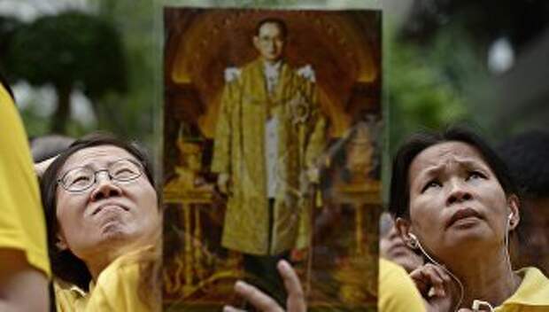 Жительницы Бангкока держат портрет короля Таиланда Пхумипона Адульядета. 2014 год