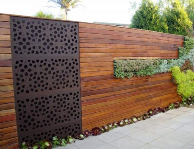 Классическое сочетание дерева и металла позволило создать необычный комбинированный забор. 