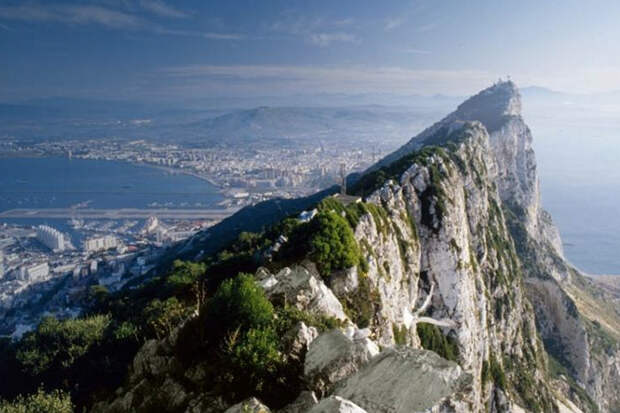 Гибралтарская скала, Гибралтар Монолитная известняковая скала высотой 426 метров образовалась около 200 млн лет назад в результате столкновения Африканской и Евразийской тектонических плит. Внутри скалы находится более 100 пещер, сформировавшихся вследствие вымывания кальцита из известняка. Скала образует полуостров, на западном склоне которого располагается сам город и заповедник берберийских макак.