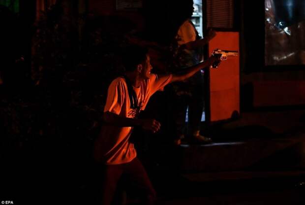 Человек играет с игрушечным пистолетом (в городе Мандалуонг, к востоку от Манилы) дутерте, филиппины против наркотиков