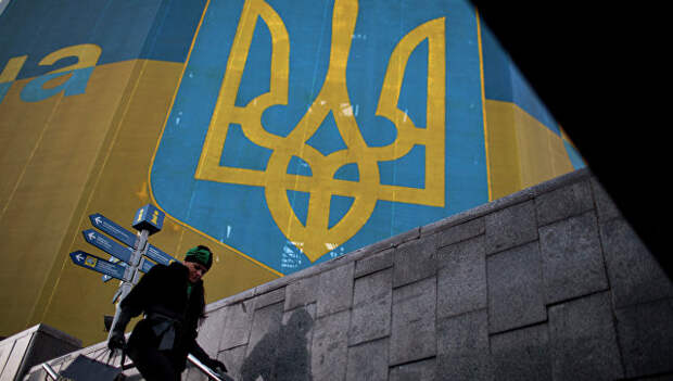 Женщина проходит мимо огромного украинского флага в центре Киева. Архивное фото
