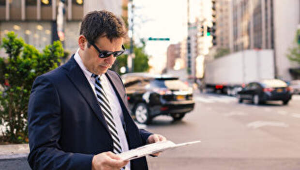 Мужчина читающий газету на Манхеттене. Архивное фото
