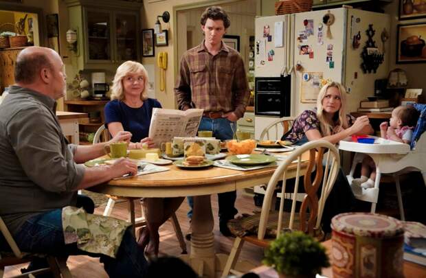 Georgie standing by the family table while everyone else is eating on Georgie & Mandy Season 1 Episode 2
