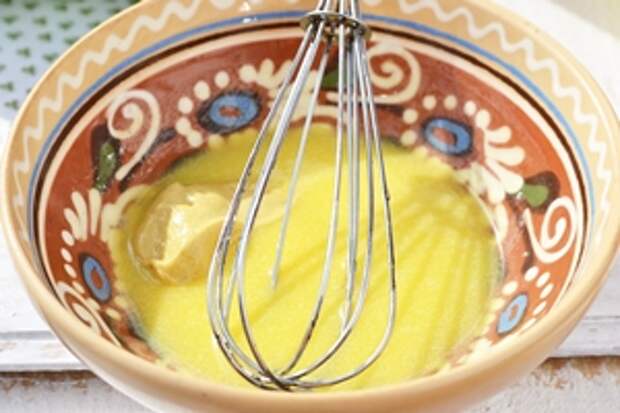 Смешиваем желток с горчицей с помощью венчика в керамической миске