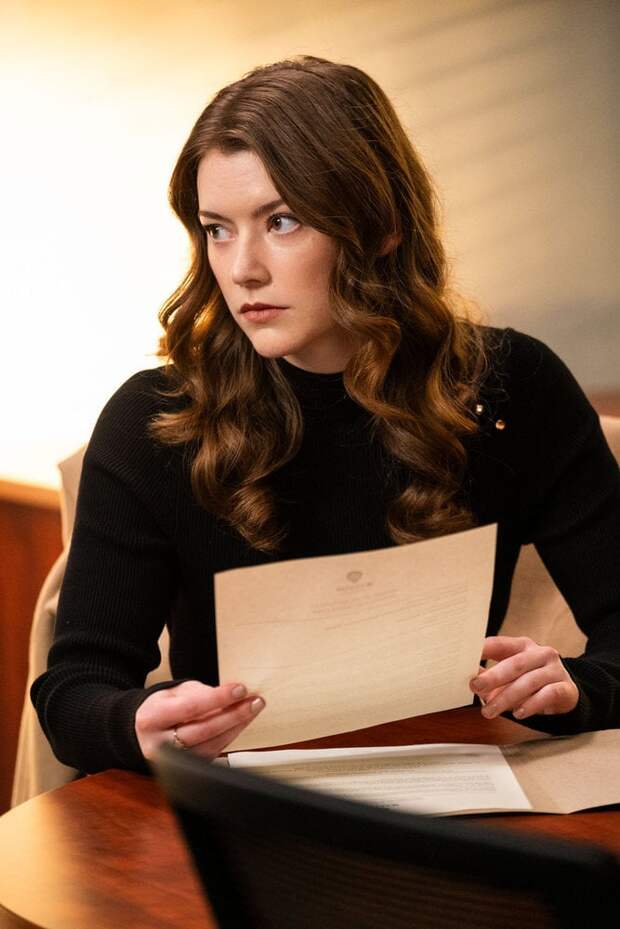 Phoebe looks annoyed as she examines a paper on The Irrational Season 2 Episode 3