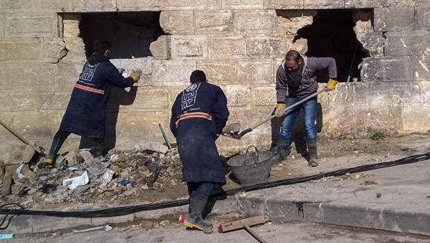 Горожане во время уборке на улице в районе Аль Назирия в сирийском Аллепо. Архивное фото