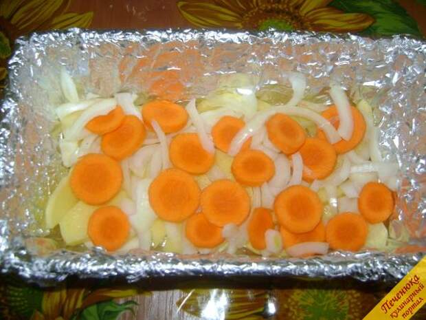 3) В форму, в которой будет готовится щука в духовке с картофелем, положить пергамент или фольгу, далее слой картофеля на дно, за ним — лук и морковь.