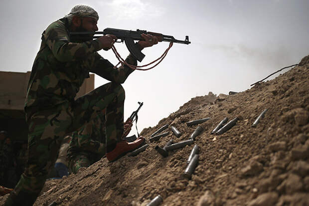 A volunteer from the Badr Brigade militia fires on ISIS fighters from the frontline on April 11, 2015 in Ebrahim Ben Ali, in Anbar Province, Iraq. Shia militia and Iraqi government troops are preparing for an assault on ISIS forces in Anbar, much of which was captured by ISIS forces last year. 