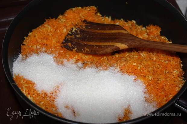 Добавьте к моркови и стружке сахар, перемешайте и обжаривайте 10 мин, постоянно помешивая.