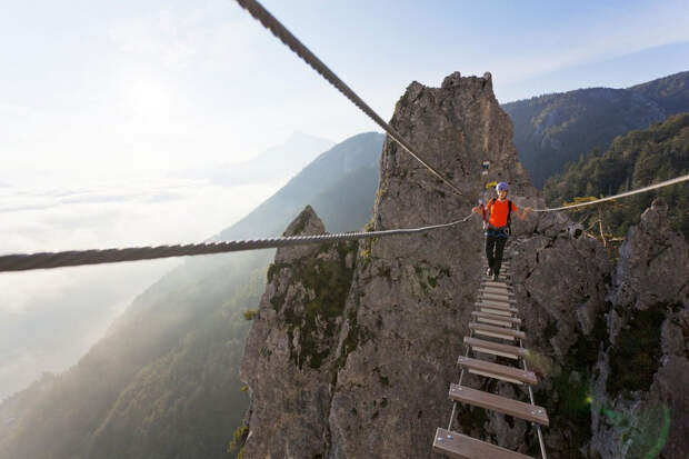 Young woman crossing Dragon wall rope bridge