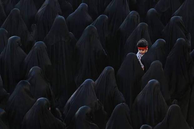 Мусульманская женщина с сыном принимают участие в похоронах Иса Радхи. Автор фотографии: Иса Эбраим (Isa Ebrahim).