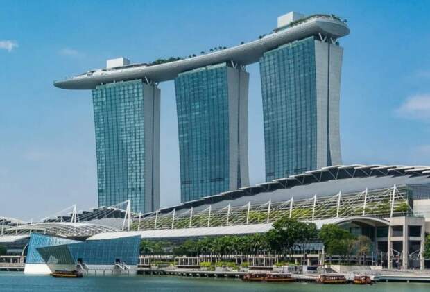 Marina Bay Sands представляет собой комплекс из трех башен в виде карточных колод / Фото: okoguide.com Marina Bay Sands представляет собой комплекс из трех башен в виде карточных колод / Фото: okoguide.com