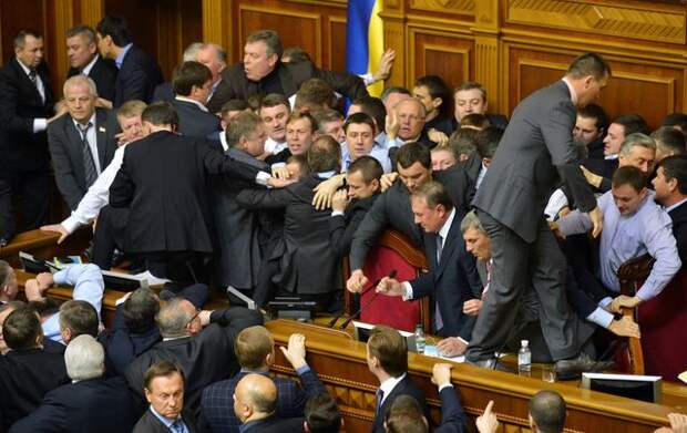 Deputies of the opposition fight with deputies of the majority for a second time in two days, during the second session of the newly elected Ukrainian parliament in Kiev on December 13, 2012.  The opening session of the Verkhkovna Rada began in a typically raucous fashion, after the October 28 parliamentary elections which were condemned by the West as a setback for democracy.  In the meantime, a fight erupted in the chamber between opposition MPs and two deputies whom they accused of defecting to the pro-government camp. Several lawmakers from the opposition nationalist Svoboda group chased two men they called "turncoats" -- a father and a son -- to prevent them from taking the oath.   AFP PHOTO//SERGEI SUPINSKY        (Photo credit should read SERGEI SUPINSKY/AFP/Getty Images)