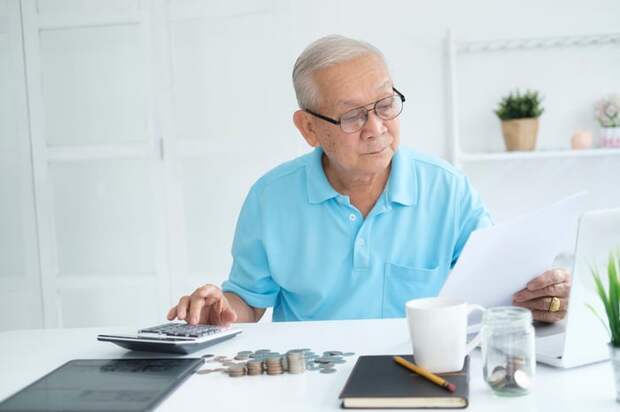 A person at a desk holding a document.