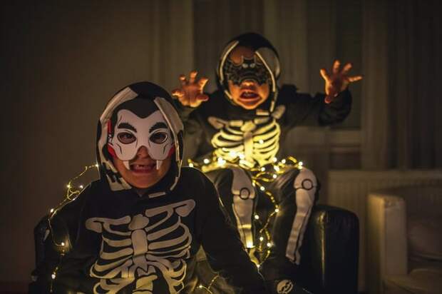 two young boys in Halloween costumes making scary faces.