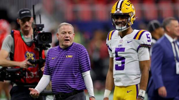 LSU coach Brian Kelly talks to QB Jayden Daniels on the field.