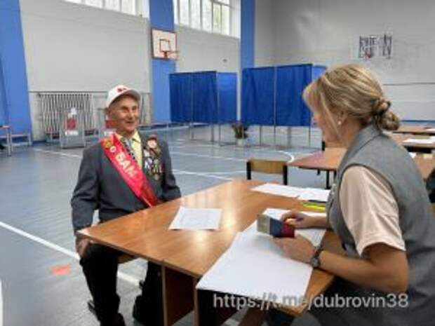 Ветеран обсуждает документы на избирательном участке.