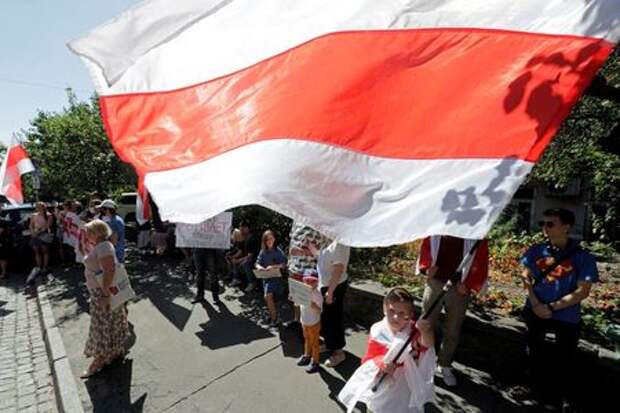 A boy waves a Belarusian historical white-red-white flag during a rally in support of anti-government protests in Belarus against presidential election results, in front of the Belarusian embassy in Kyiv, Ukraine August 30, 2020. REUTERS/Valentyn Ogirenko