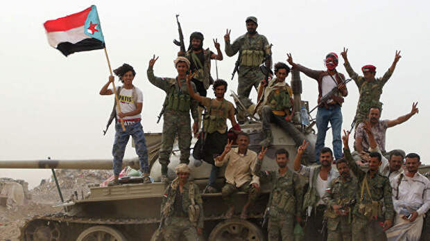 Члены поддерживаемых ОАЭ южно-йеменских сепаратистских сил стоят на танке во время столкновений с правительственными войсками в Адене, Йемен. 10 августа 2019 