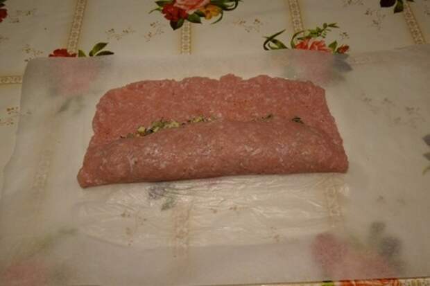 9. Приподнимаем край пергамента, накрывая начинку мясным фаршем. Мясной рулет с ананасом и сыром: фото шаг 9