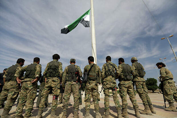 Поддерживаемые Турцией бойцы поднимают флаг сирийской оппозиции в городе Телль-Абъяд