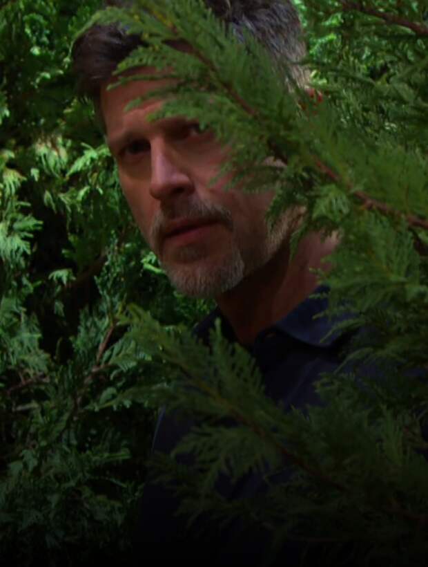 Eric hides in the bushes spying on Fiona and Sarah on Days of Our Lives