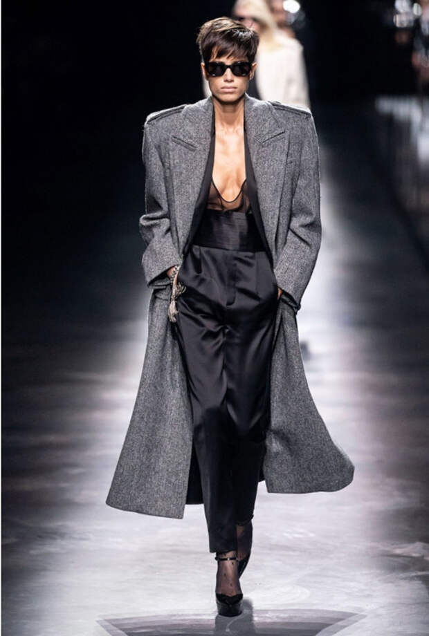 Модель в черном шелковом комбинезоне и сером пальто