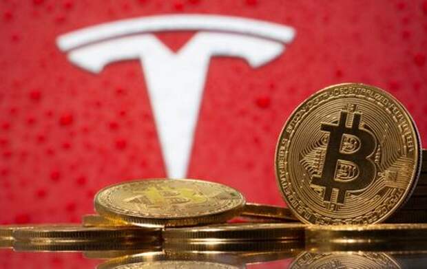 Representations of virtual currency Bitcoin are seen in front of Tesla logo in this illustration taken, February 9, 2021. REUTERS/Dado Ruvic/Illustration