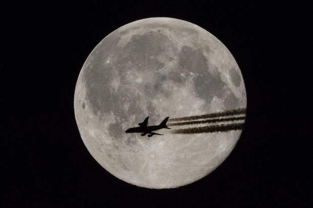 Самолет на фоне полной Луны