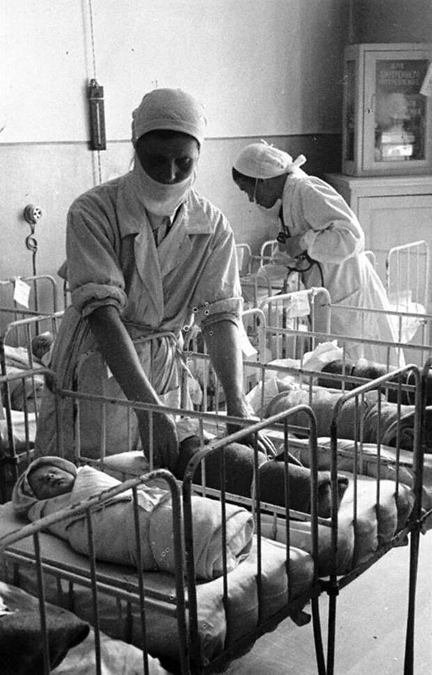 Медицинские сестры укладывают новорожденных в кроватки в детской комнате родильного дома имени профессора Снегирева. 1942 г. Ленинград.