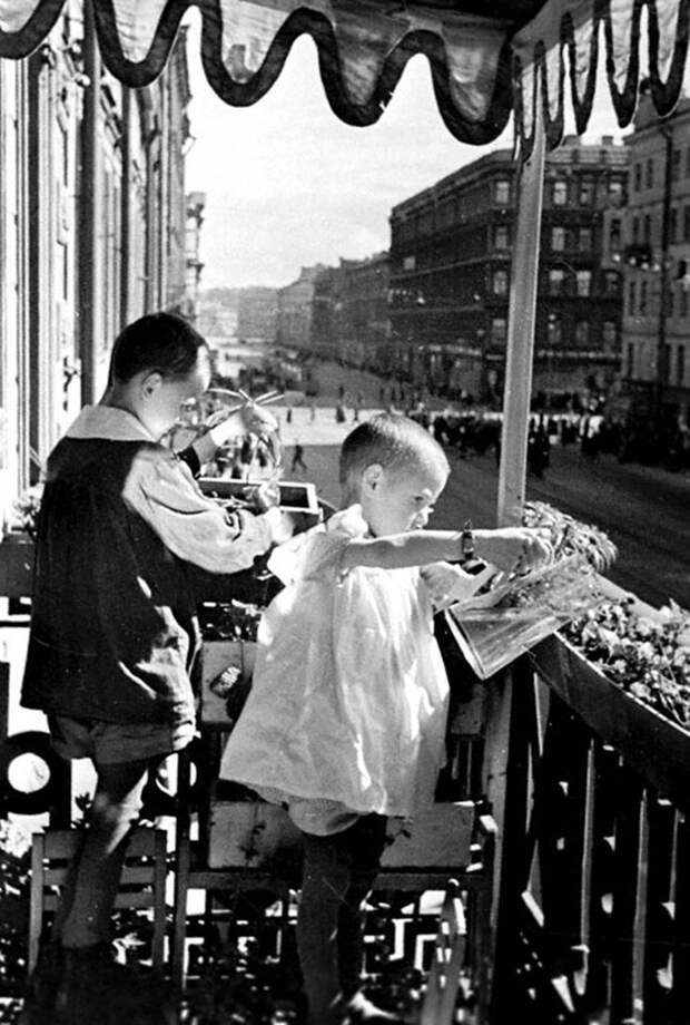 Дети Г.Сухарев и Т.Хабаева поливают овощи на балконе детского дома Куйбышевского района по проспекту Володарского.  1942 г. Ленинград.