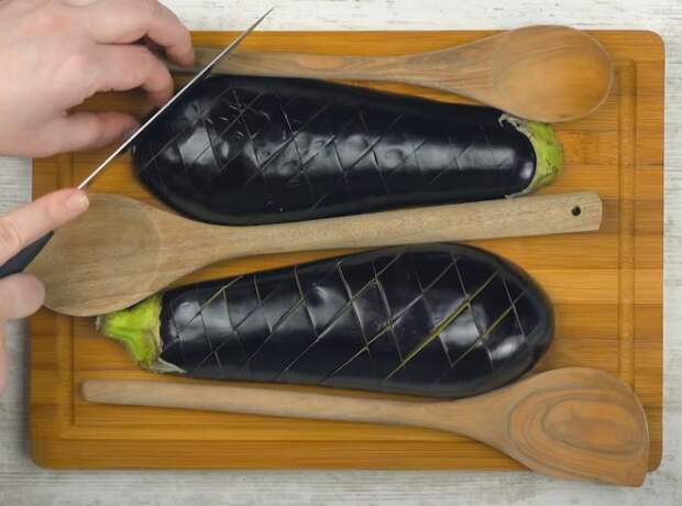 Деревянные ложки или шпажки помогают сделать глубокие надрезы, не прорезая баклажан насквозь. /Фото: youtube.com/watch?v=3JcEu9FE9us