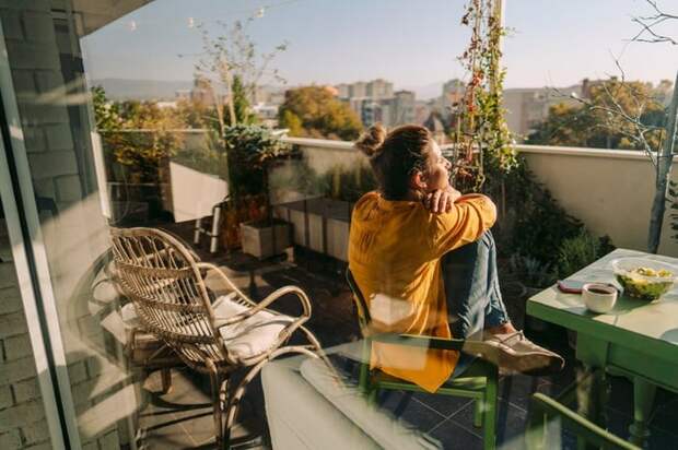 Woman sitting outside on her condo balcony.