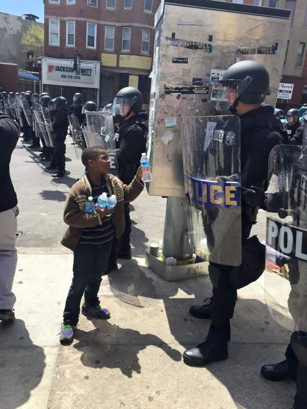 A Boy Giving Water To The Officers