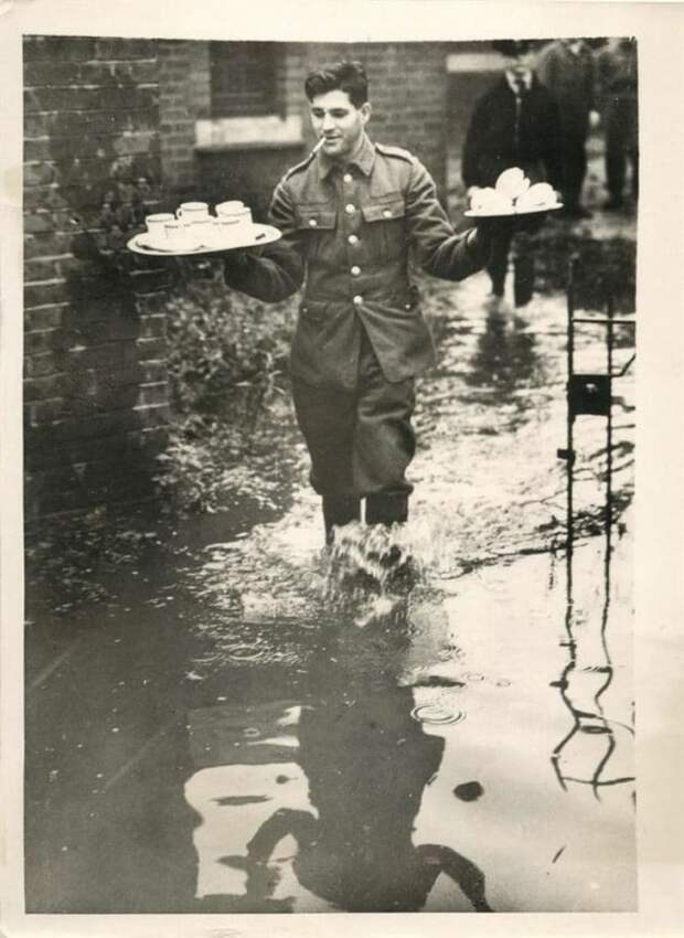 Британский солдат несёт чай своим товарищам, работающим на ликвидации последствий наводнения в южном Лондоне, 1939 год.