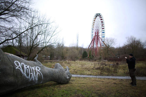 Стекловолоконный динозавр в заброшенном парке в Берлине
