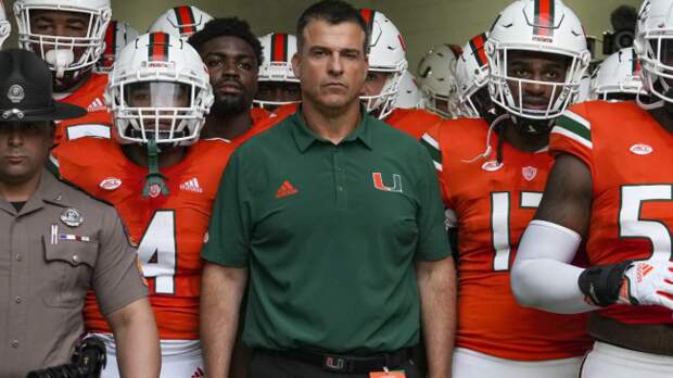 Mario Cristobal leads the Miami Hurricanes onto the field.