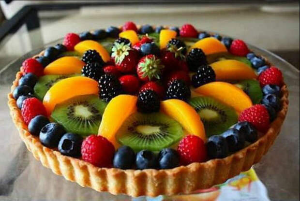 Бисквит, украшенный фруктами и ягодами.