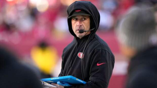 san francisco 49ers coach kyle shanahan wearing a blace hooded sweatshirt