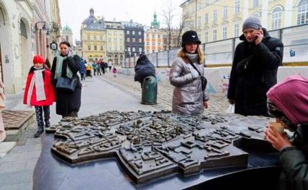 На фото: прохожие рассматривают на карту Львова
