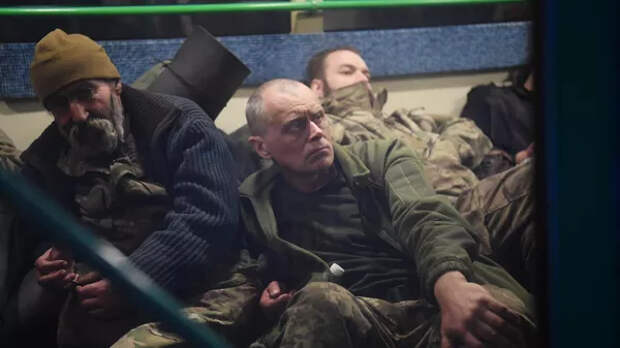Сдавшиеся в плен украинские военнослужащие и боевики националистического батальона Азов сидят в автобусе у следственного изолятора в Еленовке