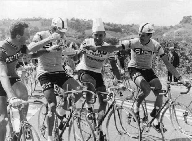 Велогонщики перекусывают на ходу во время прохождения этапа велогонки Джиро д'Италия. 