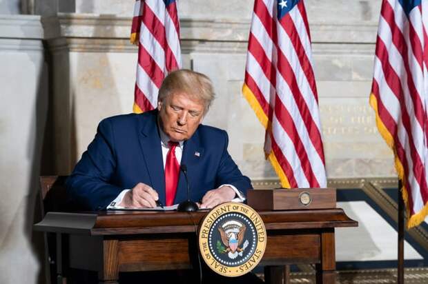 President-Elect Donald Trump signing a document during his first term.