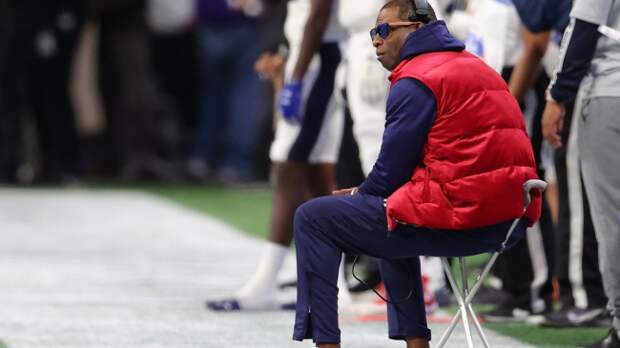 Deion Sanders sits on the sidelines.