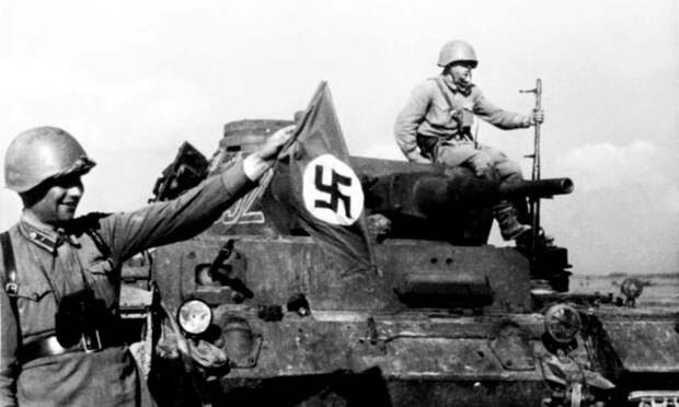 Красноармейцы на фоне танка Pz.Kpfw. III Ausf. E из 3-й танковой дивизии вермахта, подбитого под Могилевом. Прорвавшиеся к советским окопам немецкие танки были расстреляны огнем в борт и корму. На переднем плане — командир 3-го батальона 388-го стрелкового полка капитан Гаврюшин Д.С. В руке у бойца немецкий 7,92-мм авиационный пулемет MG.15. 20.07.1941 Фото: Павел Трошкин