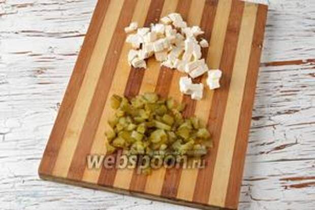 Солёные огурцы (80 г) и плавленый сыр (100 г) нарезать небольшими кубиками.