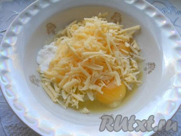 К яйцам добавить сметану и натертый на крупной терке твердый сыр. Хорошенько все перемешать венчиком. Посолить по вкусу. 