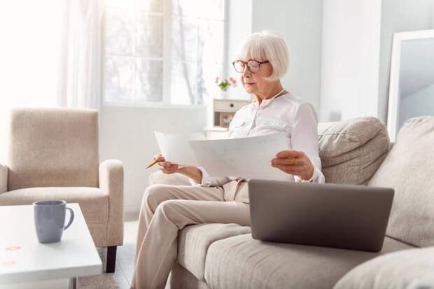 Person looking at documents on couch.