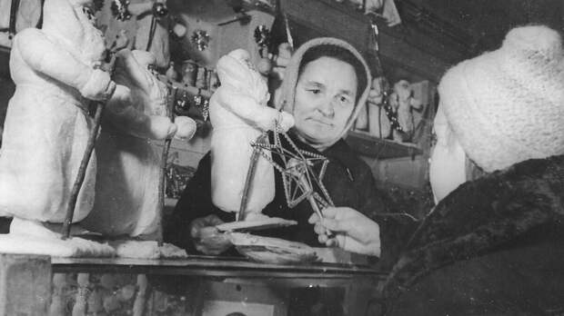 Продавщица отдела игрушек одного из магазинов Ленпромторга К.И. Цыганенко показывает юной покупательнице елочные украшения, 1942 год. ЦГАКФФД СПб